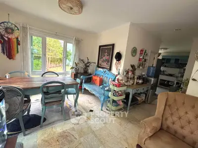 Charming living room with eclectic decor and garden view, featuring vintage furniture and natural light.
