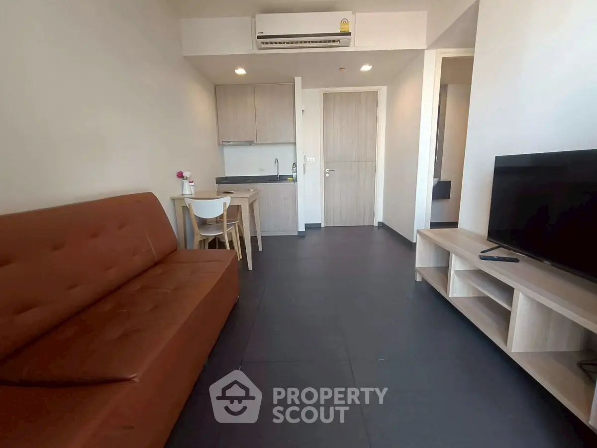Modern living room with sleek furniture and compact kitchen area