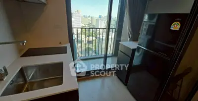 Modern kitchen with city view, featuring sleek appliances and a compact balcony.