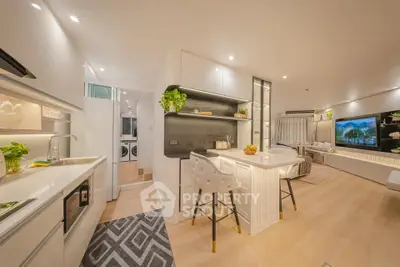 Modern open-plan kitchen and living room with stylish decor and ample lighting.
