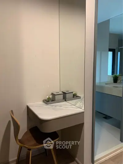 Modern bathroom with sleek vanity and mirror, featuring minimalist decor and natural light.