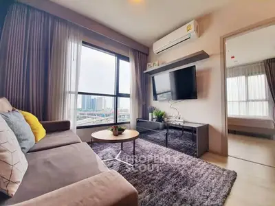 Modern living room with large window and city view, featuring cozy sofa and wall-mounted TV.