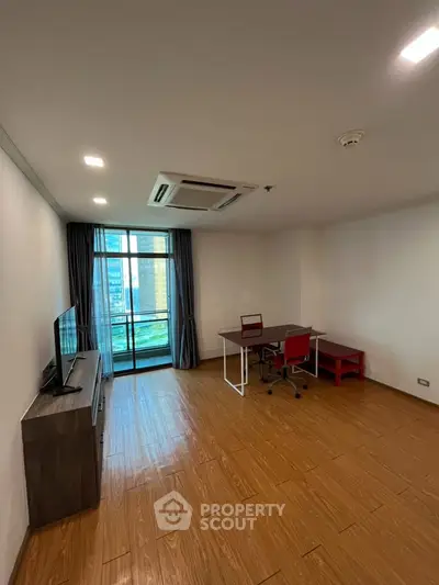 Spacious living room with modern furniture and city view balcony.