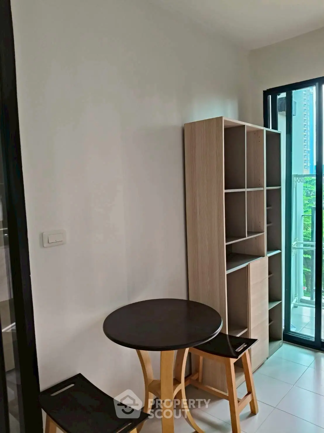 Cozy corner with table and chairs next to a balcony in a modern apartment.
