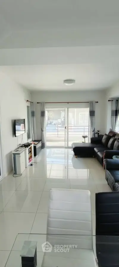 Spacious modern living room with sleek furniture and large windows for natural light.