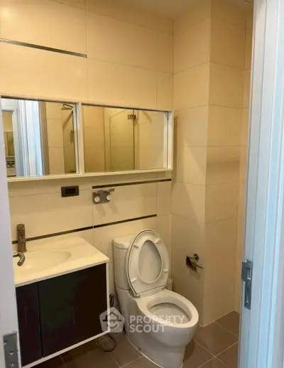 Modern bathroom with sleek fixtures and large mirror in contemporary apartment.