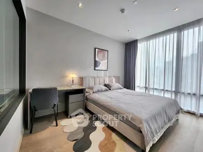 Modern bedroom with large window and stylish decor in a contemporary apartment.