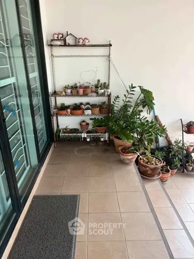 Charming balcony with potted plants and tiled flooring, perfect for relaxation and gardening enthusiasts.