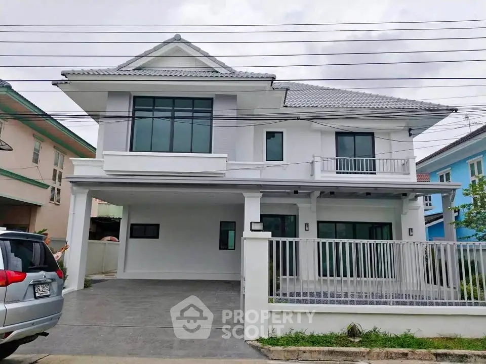 Modern two-story house with spacious driveway and sleek design in a suburban neighborhood.