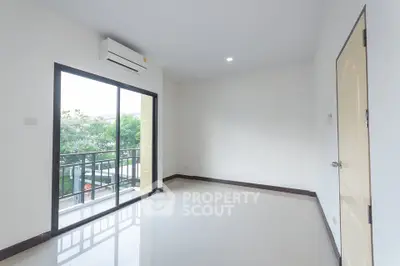 Spacious empty room with large window and balcony access, perfect for customization.