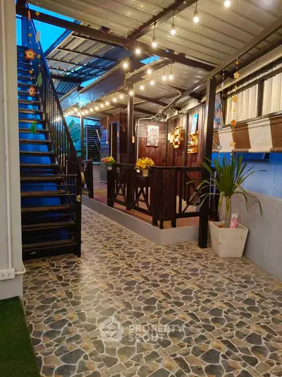 Charming outdoor corridor with decorative lighting and stone flooring, perfect for cozy evenings.