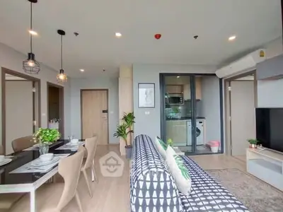 Modern open-plan living room with stylish decor and kitchen view in a contemporary apartment.