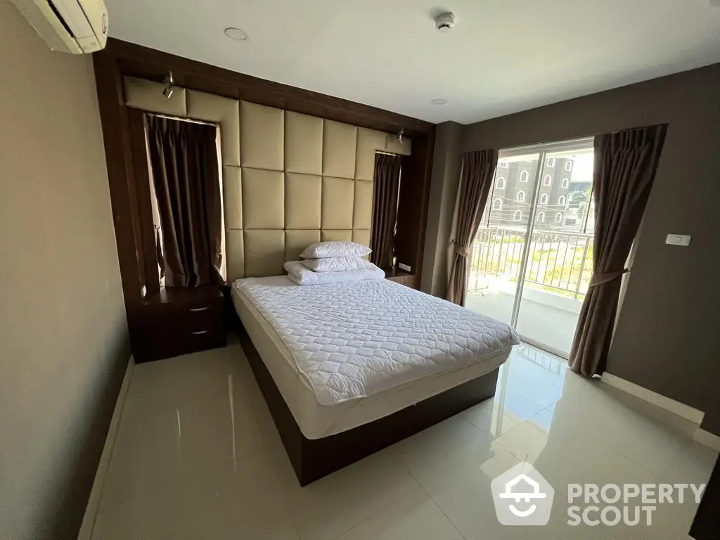 Spacious bedroom with glossy tiled floors, a large comfortable bed, and elegant dark curtains, offering a serene and luxurious living space.