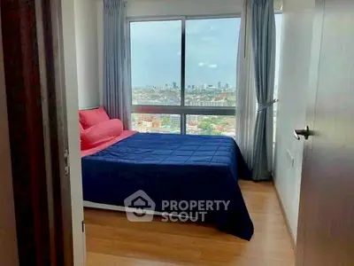 Cozy bedroom with stunning city view and large windows, perfect for relaxation and comfort.
