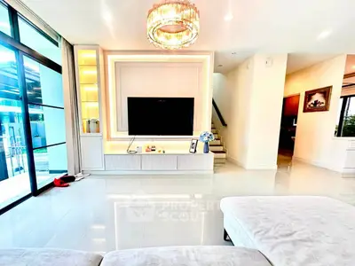Luxurious living room with modern decor and large TV, featuring elegant lighting and spacious design.