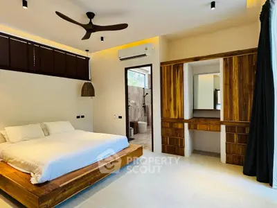 Modern bedroom with wooden furniture and ensuite bathroom in luxury home