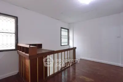 Spacious interior with wooden flooring and stairway, ideal for customization.