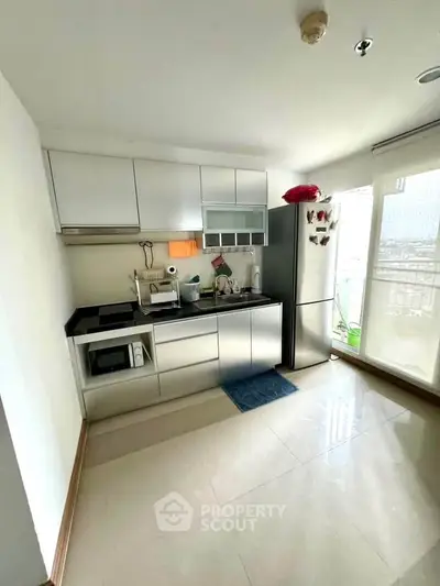 Modern kitchen with sleek cabinets and stainless steel appliances in bright apartment