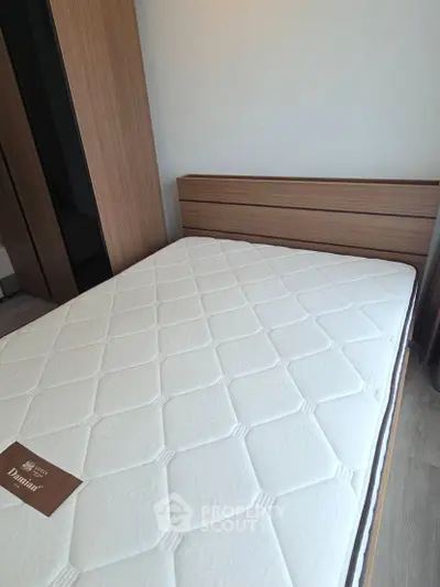 Modern bedroom with stylish wooden bed frame and comfortable mattress in a cozy setting.