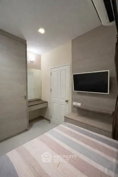 Cozy modern bedroom with built-in wardrobe and wall-mounted TV