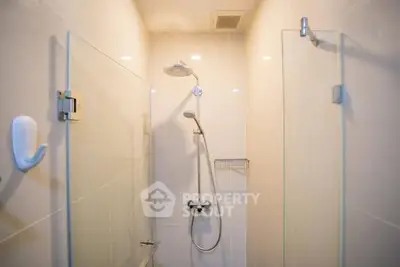 Modern minimalist bathroom shower with glass enclosure and sleek fixtures