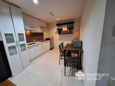 Modern kitchen with dining area, featuring sleek cabinetry and compact design.