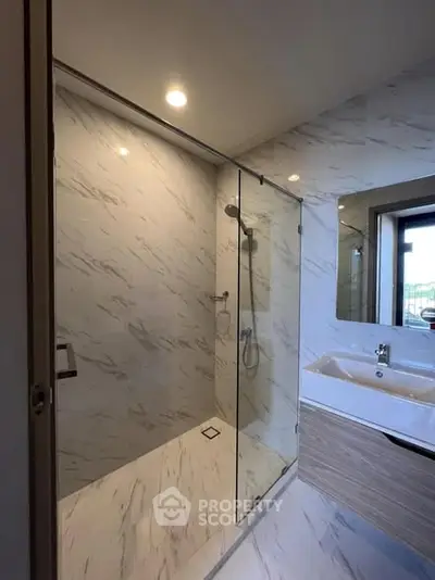 Modern bathroom with glass shower and sleek vanity in luxury home.
