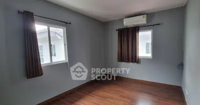 Spacious empty room with wooden flooring and air conditioning, perfect for customization.