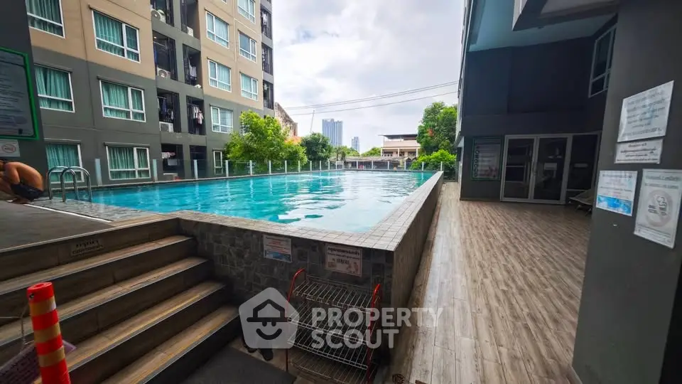 Modern condominium with inviting pool and urban skyline view, perfect for relaxation and city living.