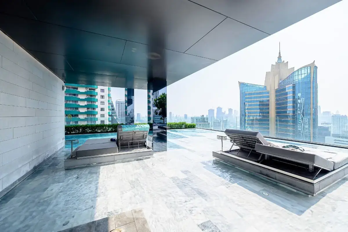Luxurious rooftop pool with stunning city skyline views in modern high-rise building.