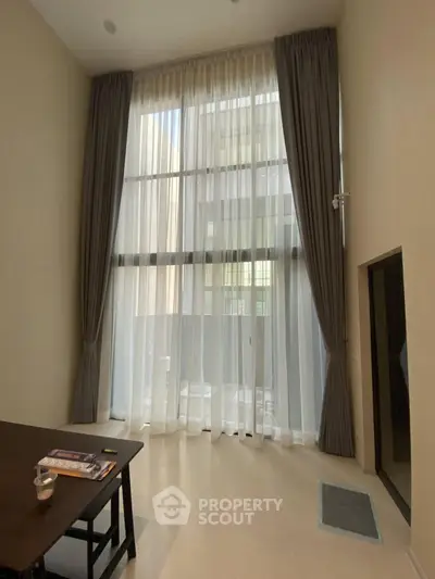 Spacious living room with high ceilings and large windows for natural light.