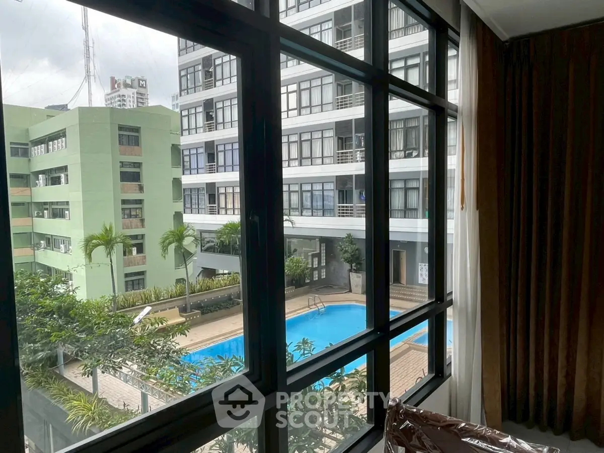 Stunning pool view from modern apartment window, perfect for urban living.