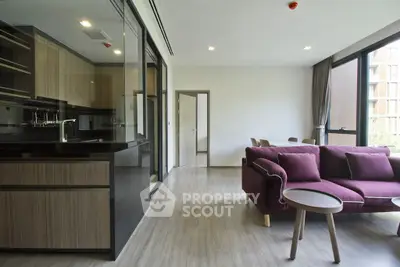 Modern open-layout living room with sleek kitchen and stylish furniture in a bright apartment.