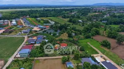 Aerial view of suburban neighborhood with lush greenery and distant mountains.