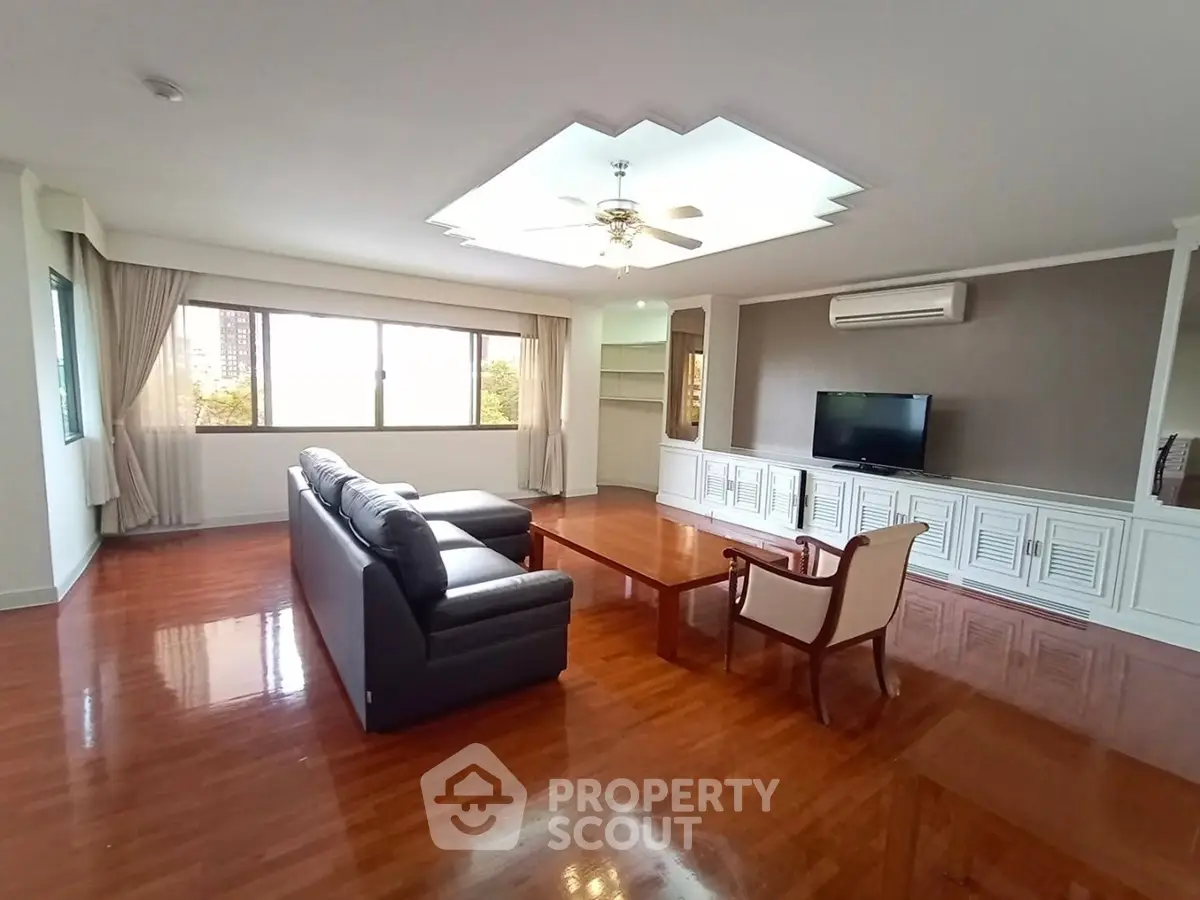 Spacious living room with elegant hardwood floors and modern furnishings in a luxury apartment.