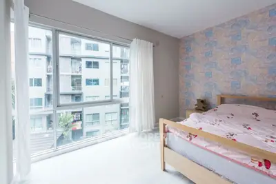 Bright bedroom with large windows and modern decor in urban apartment