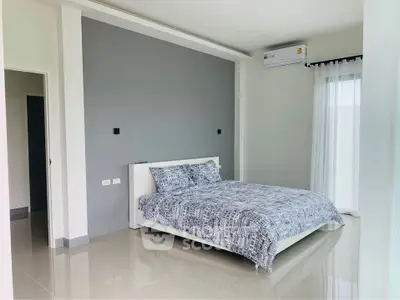 Spacious bedroom with polished tile flooring, modern air conditioning unit, and large windows draped with sheer curtains offering ample natural light.