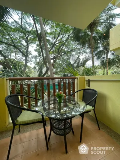 Charming balcony with lush green view and cozy seating area