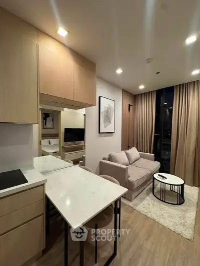 Modern living room with cozy sofa, stylish decor, and open kitchen layout in a contemporary apartment.