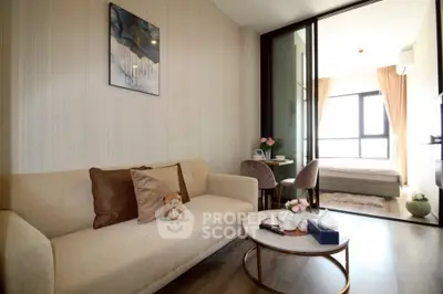 Modern living room with cozy sofa and stylish decor leading to a bright bedroom.