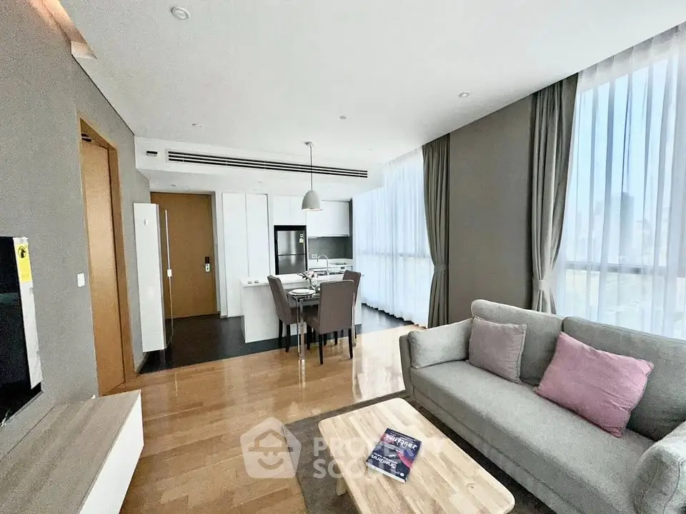 Spacious modern living room with open kitchen and large windows in a stylish apartment.