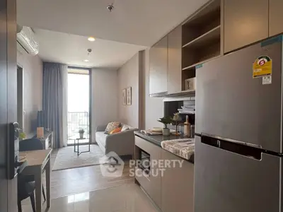 Modern open-layout kitchen and living room with stylish decor and natural light.