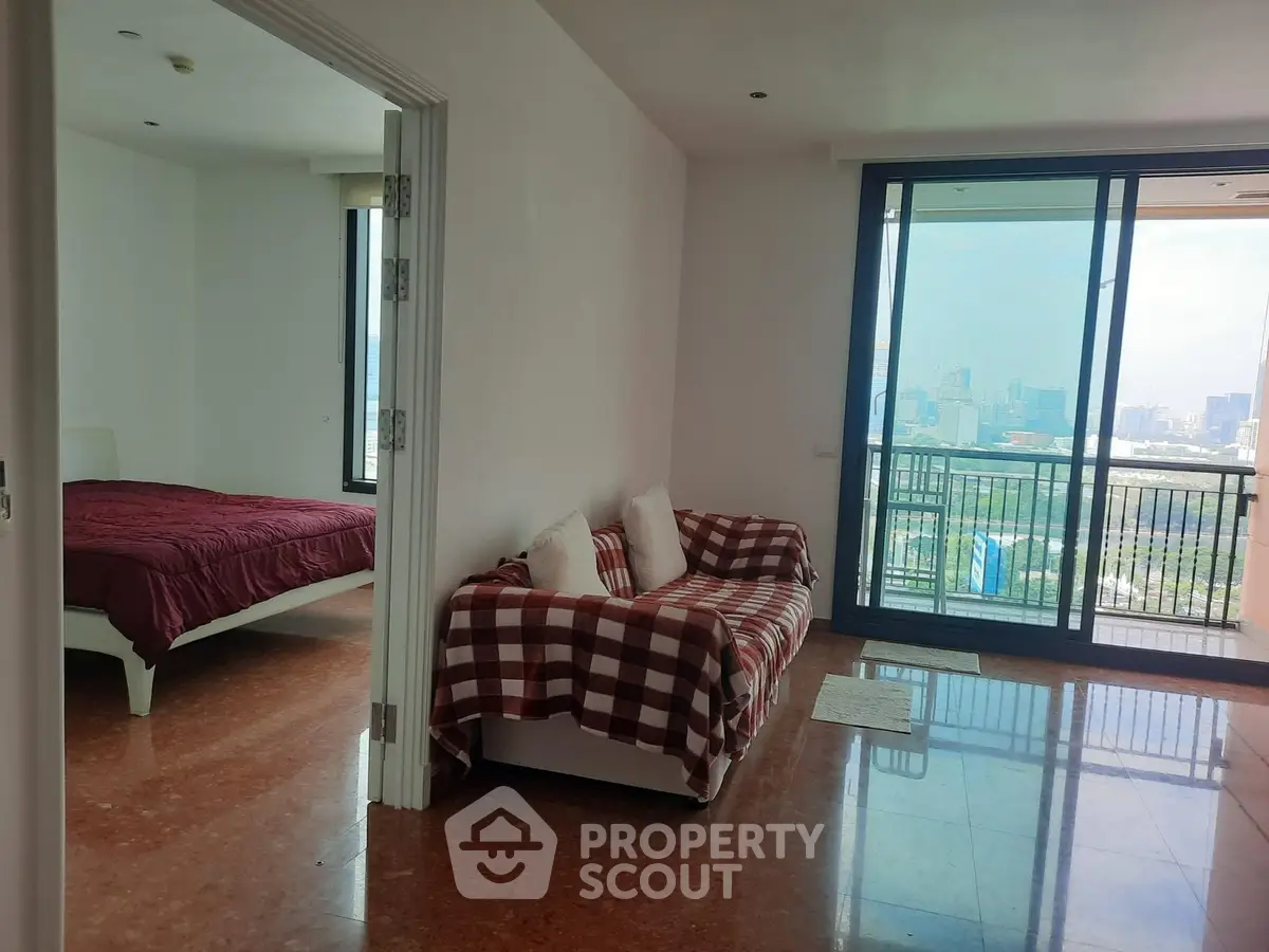 Spacious apartment with city view, featuring a cozy living area and bedroom with large windows.