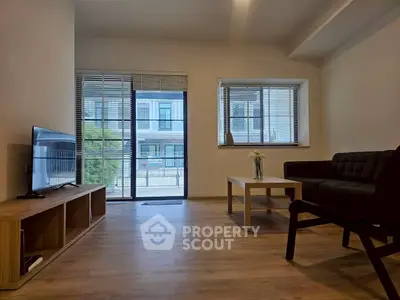 Modern living room with sleek furniture and large windows offering natural light.