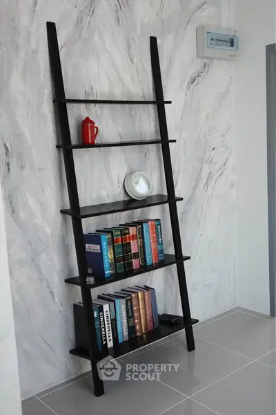 Modern interior with stylish ladder bookshelf and marble accent wall, perfect for contemporary living spaces.
