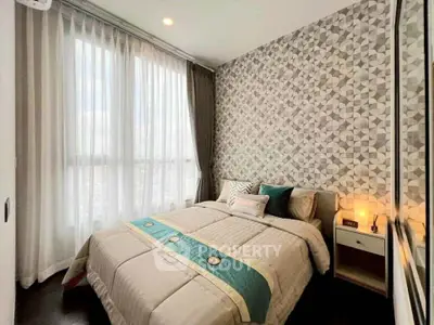 Modern bedroom with stylish geometric wallpaper and large window for natural light.