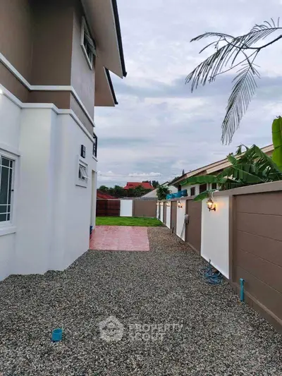 Modern house exterior with gravel pathway and garden wall lighting
