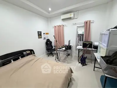 Cozy bedroom with modern decor, featuring a workspace and musical instruments, ideal for creative living.
