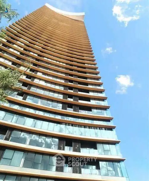 Stunning modern high-rise building with unique architectural design against blue sky.