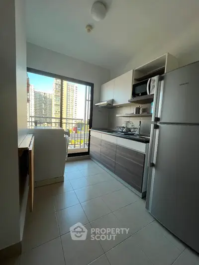 Modern kitchen with city view, featuring sleek cabinets and stainless steel appliances.